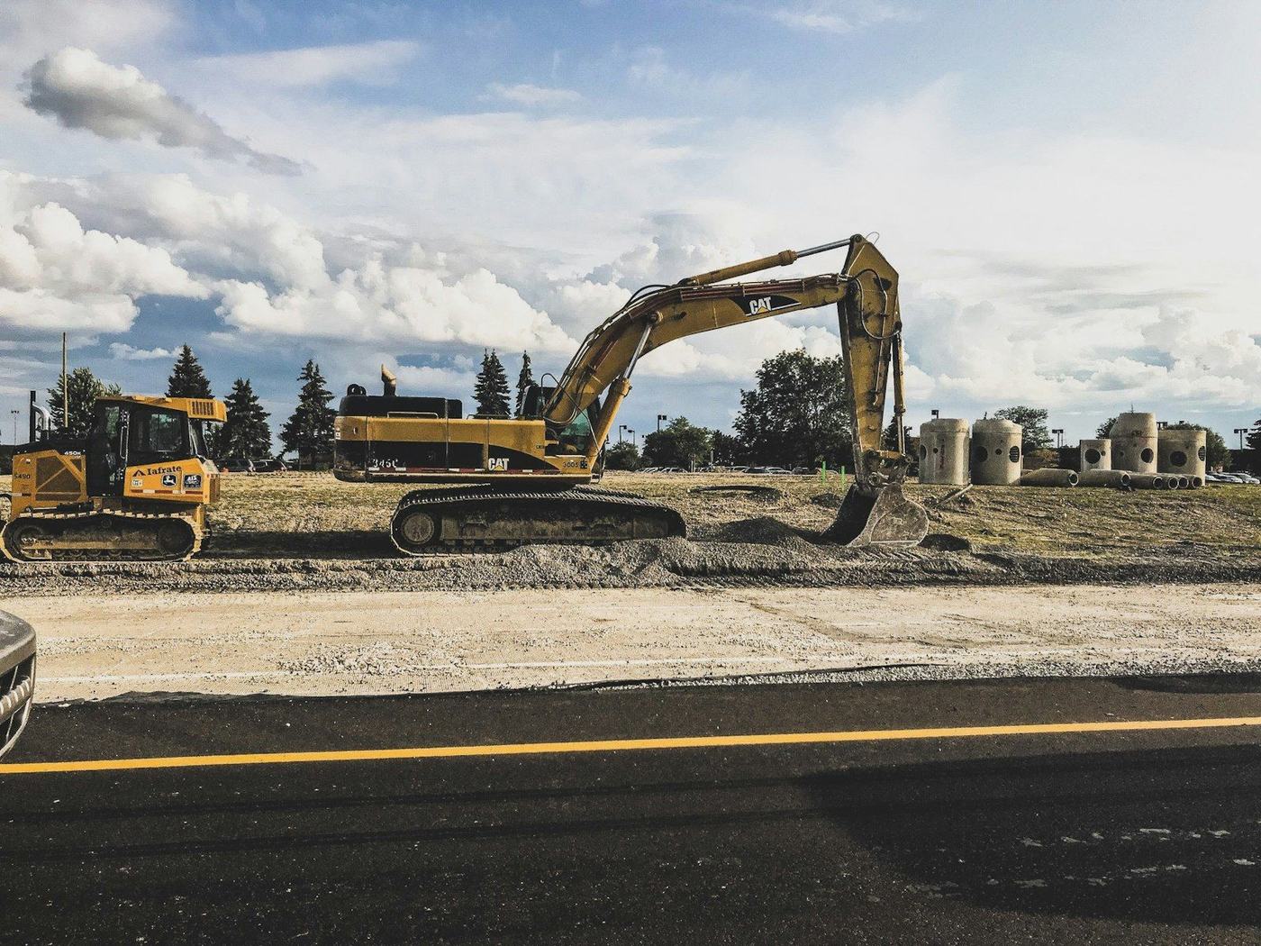 Excavators and earthmoving plant working beside a newly laid road